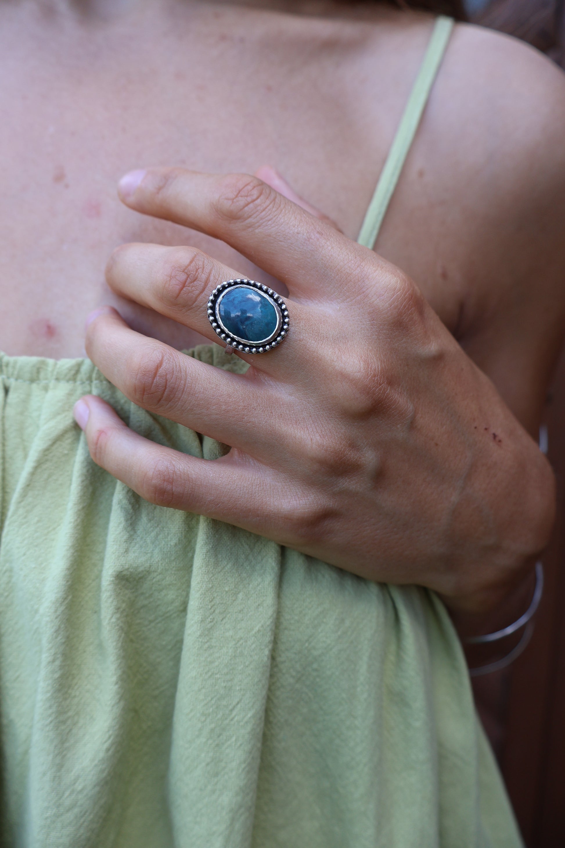 Side angle of sterling daisy ring showcasing bezel‑set Hubei turquoise