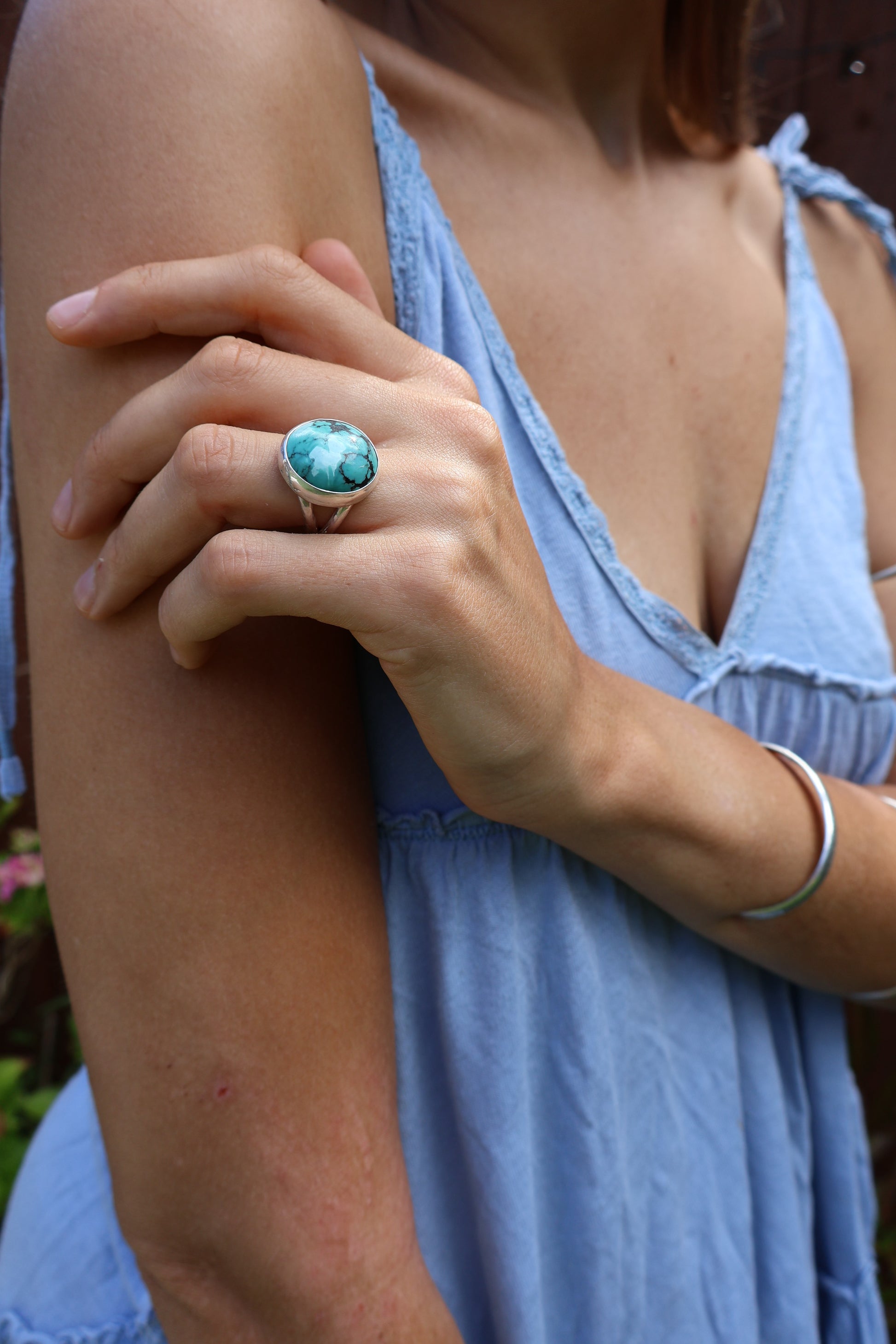 Earthy woman wearing handmade turquoise ring in natural setting