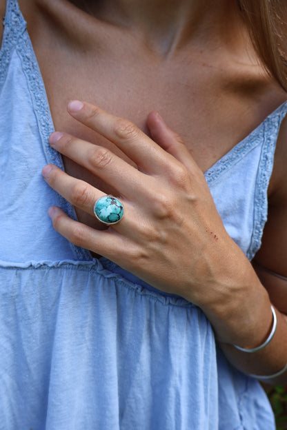 Woman grounding in nature with chunky turquoise statement ring