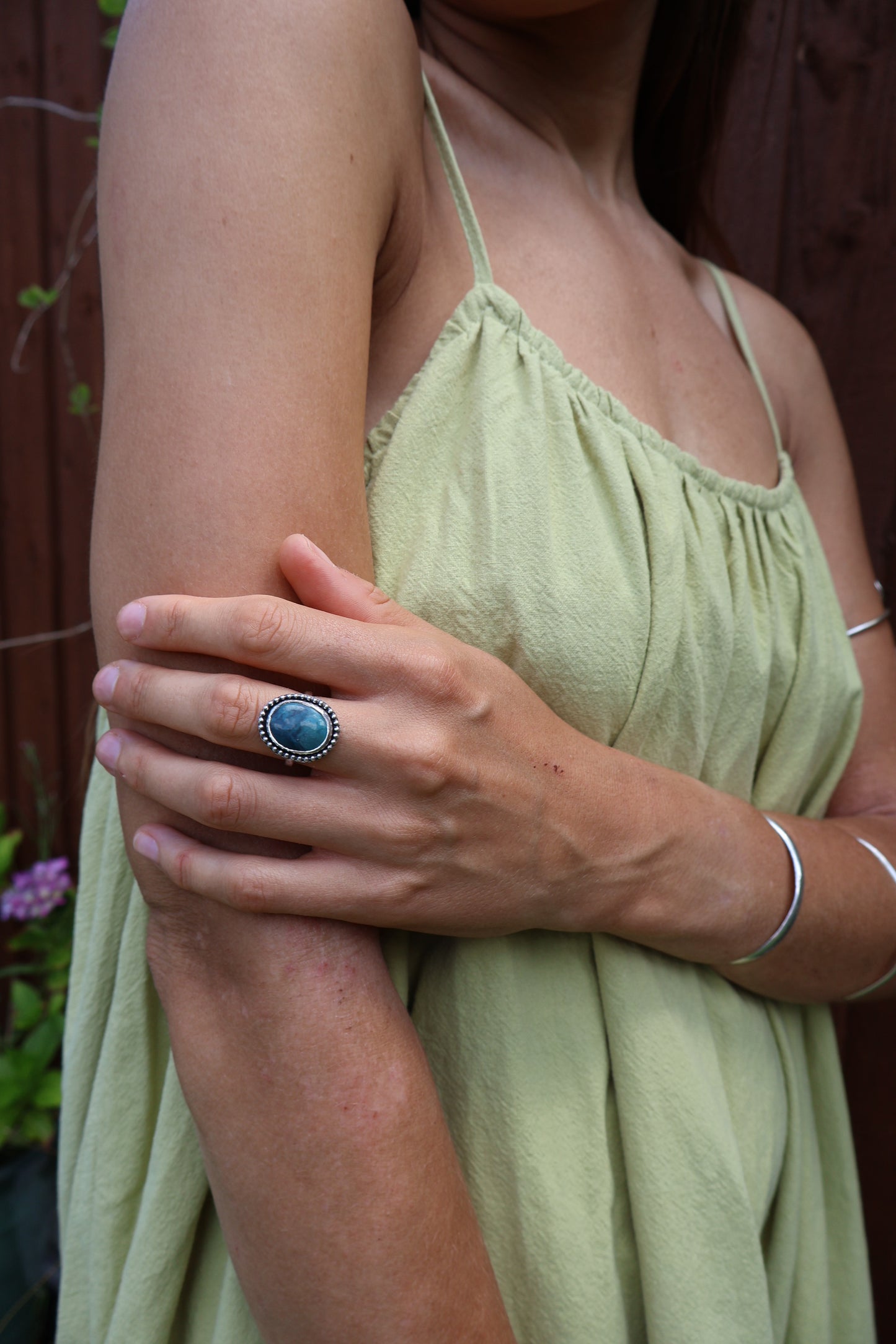 Hand model wearing daisy-style sterling silver ring with Hubei turquoise